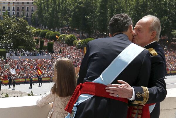Испанский король Фелипе VI обнимается с бывшим королем Испании Хуаном Карлосом, в то время как принцесса София машет с балкона  - Sputnik Литва