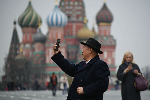 Турист фотографируется на Красной площади в Москве, на фоне храма Василия Блаженного - Sputnik Литва