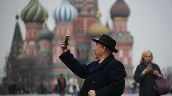 Турист фотографируется на Красной площади в Москве, на фоне храма Василия Блаженного - Sputnik Lietuva