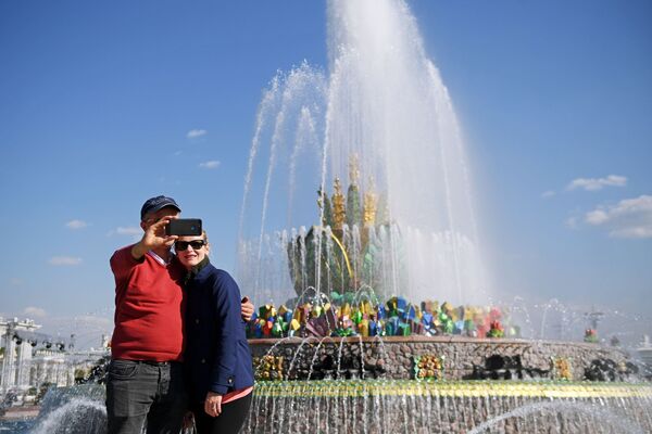 Отдыхающие фотографируются у заработавшего фонтана Каменный цветок на ВДНХ в Москве - Sputnik Литва