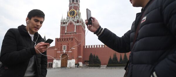 Молодые люди фотографируются на Красной площади у Московского Кремля Молодые люди фотографируются на Красной площади у Московского Кремля - Sputnik Lietuva