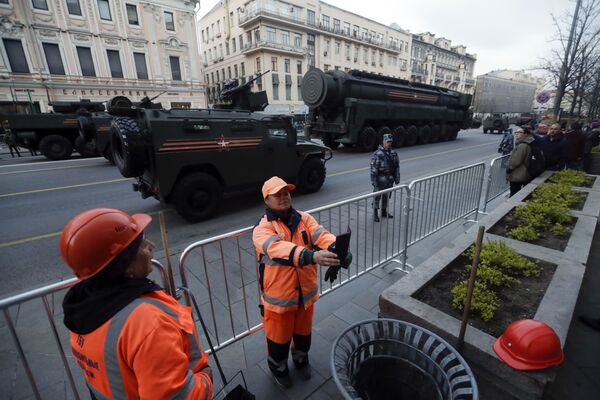 Городские работники делают селфи напротив колонны военной техники на улицах Москвы во время репетиции Парада Победы - Sputnik Литва