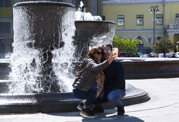 Отдыхающие фотографируются у фонтана на Театральной площади в Москве - Sputnik Литва
