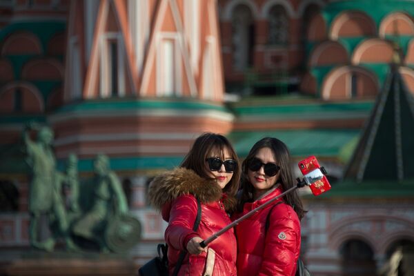 Девушки делают селфи на фоне храма Василия Блаженного в Москве - Sputnik Литва
