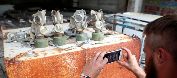 Посетитель фотографирует противогазы на бывшей базе Советской армии, недалеко от Чернобыльской АЭС, Украина, 2 июня 2019 года Посетитель фотографирует противогазы на бывшей базе Советской армии, недалеко от Чернобыльской АЭС, Украина, 2 июня 2019 года - Sputnik Lietuva