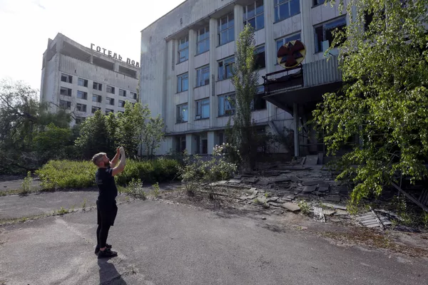 Посетитель фотографирует здание в заброшенном городе Припять, недалеко от Чернобыльской АЭС, Украина, 2 июня 2019 года Посетитель фотографирует здание в заброшенном городе Припять, недалеко от Чернобыльской АЭС, Украина, 2 июня 2019 года
