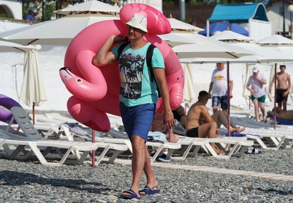 Мужчина с надувным кругом на пляже в районе Адлер города Сочи - Sputnik Литва