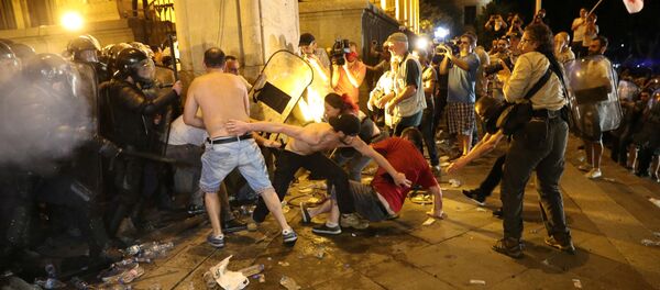 Столкновения демонстрантов с сотрудником ОМОНа у здания парламента во время митинга против визита российских законодателей в Тбилиси, Грузия, 21 июня 2019 года Столкновения демонстрантов с сотрудником ОМОНа у здания парламента во время митинга против визита российских законодателей в Тбилиси, Грузия, 21 июня 2019 года - Sputnik Lietuva