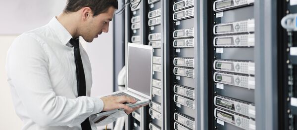 Мужчина с ноутбуком в сетевой комнате сервера, архивное фото - Sputnik Литва