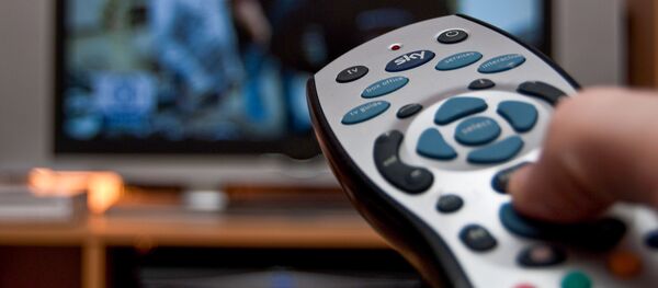 Мужчина держит пульт перед телевизором, архивное фото - Sputnik Литва