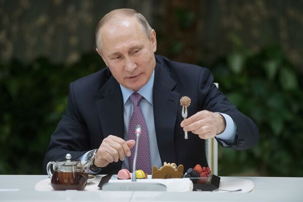 Rusijos prezidentas Vladimiras Putinas ragauja desertą iškilmingame priėmime su Metų šeimos konkurso nugalėtojais. - Sputnik Lietuva