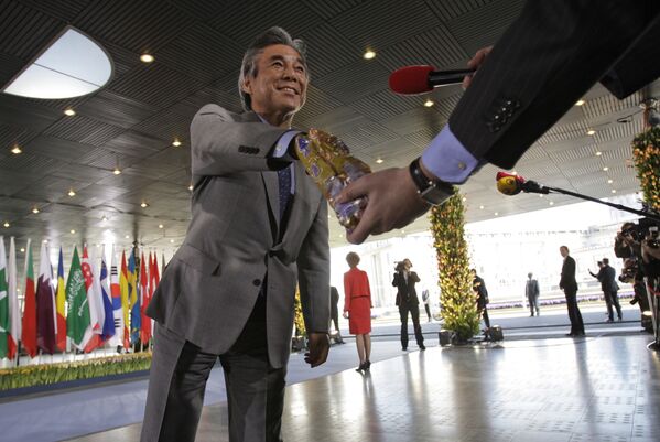 Министр иностранных дел Японии Хирофуми Накасонэ берет шоколадку из пакета репортера голландского телеканала на конференции в Гааге, Нидерланды - Sputnik Lietuva