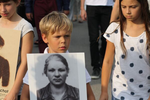 Мальчик несет фото погибшего в Молетй родственника Мальчик несет фото погибшего в Молетй родственника - Sputnik Литва