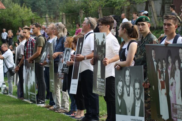 Фотографии в руках потомков на месте расстрела евреев в Молетай Фотографии в руках потомков на месте расстрела евреев в Молетай - Sputnik Литва