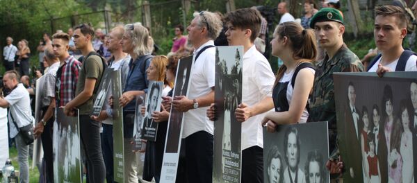 Фотографии в руках потомков на месте расстрела евреев в Молетай - Sputnik Литва