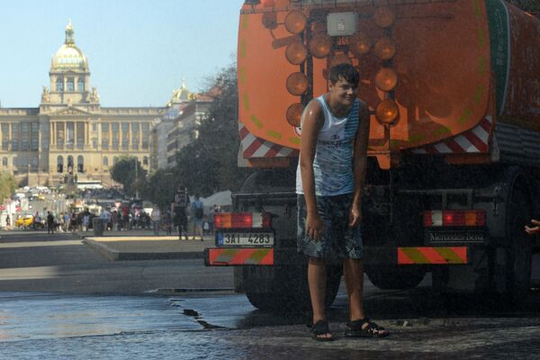 Мальчик остывает под струей воды во время жаркого дня на Вацлавской площади в Праге - Sputnik Lietuva