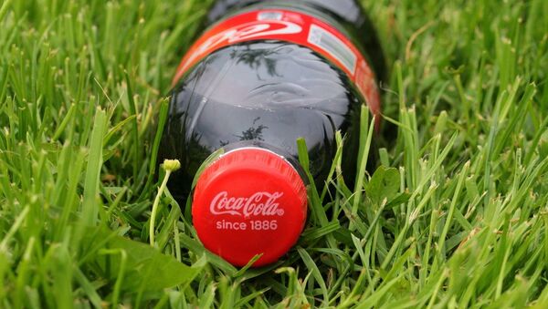 Банка напитка Coca-Cola в траве - Sputnik Литва