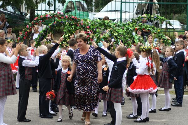 Школьники держат арку из цветов для учителей Школьники держат арку из цветов для учителей - Sputnik Литва