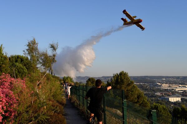 Пожарный самолет Canadair сбрасывает воду над огнем, вспыхнувшим в промышленной зоне Витроль на юго-востоке Франции - Sputnik Lietuva